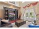 Elegant living room with a dark wood entertainment center, hardwood floors, and bright curtains leading to a pool at 108 Sagecrest Dr, Ocoee, FL 34761