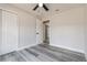 Bright bedroom with neutral paint, gray wood look floors, ceiling fan, and closet for ample storage at 1105 Valencia Ave, Haines City, FL 33844