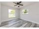 Bright bedroom with two windows, a ceiling fan, and light gray walls at 1105 Valencia Ave, Haines City, FL 33844