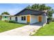 Bright single-story home with a modern carport, fresh white paint, and an eye-catching yellow front door at 1105 Valencia Ave, Haines City, FL 33844