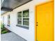 Close-up of a vibrant yellow front door and adjacent window showcasing the house number, 1105 at 1105 Valencia Ave, Haines City, FL 33844