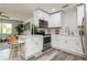 Modern kitchen features white cabinets, stainless steel appliances, and wood-look tile flooring at 1105 Valencia Ave, Haines City, FL 33844