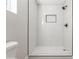 Modern all-white tiled shower with a sleek bronze shower head and hardware at 1105 Valencia Ave, Haines City, FL 33844
