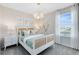 Cozy bedroom featuring a decorative light fixture, a large window, and a bed with stylish pillows at 11328 Blue Bay Dr, Orlando, FL 32832