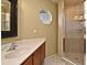 Bathroom featuring a tile shower with glass door, single sink vanity, and octagon window at 11994 Mckinnon Rd, Windermere, FL 34786