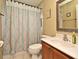 Bathroom with patterned shower curtain, toilet, and vanity with sink and framed mirror at 11994 Mckinnon Rd, Windermere, FL 34786