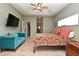 This bedroom features a ceiling fan, TV, and a comfortable blue couch, perfect for relaxing at 11994 Mckinnon Rd, Windermere, FL 34786