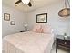 Bedroom featuring a pink comforter, ceiling fan, black nightstands, and neutral walls at 11994 Mckinnon Rd, Windermere, FL 34786