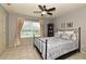 Bedroom featuring a ceiling fan, a large window with curtains, and a tiled floor at 11994 Mckinnon Rd, Windermere, FL 34786