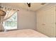 Bedroom featuring a ceiling fan, neutral walls, a window, and a double door closet at 11994 Mckinnon Rd, Windermere, FL 34786