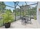 Comfortable seating area with chairs, table and umbrella inside the screened lanai at 11994 Mckinnon Rd, Windermere, FL 34786