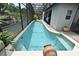 Sparkling pool with crystal blue water inside a screened-in lanai with tropical plants around at 11994 Mckinnon Rd, Windermere, FL 34786