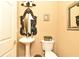 Stylish powder room featuring a pedestal sink, toilet, and decorative mirror at 11994 Mckinnon Rd, Windermere, FL 34786