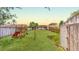 Fenced backyard featuring play equipment, storage shed, and lush green grass at 12381 Antonio Cir, Orlando, FL 32826