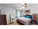 Comfortable bedroom with a ceiling fan, wood-look floors, and a striped comforter at 12381 Antonio Cir, Orlando, FL 32826