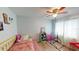 This is a bedroom with a wood floor, ceiling fan and a window with curtains at 12381 Antonio Cir, Orlando, FL 32826