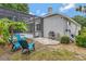 Backyard with blue chairs, brick patio, grill, and home's screened-in pool area at 12411 Scarlett Sage Ct, Winter Garden, FL 34787