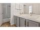 Contemporary bathroom featuring double sinks, modern fixtures, wood-look flooring and shower at 12411 Scarlett Sage Ct, Winter Garden, FL 34787
