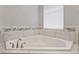 Bright bathroom featuring a corner soaking tub with tiled walls at 12411 Scarlett Sage Ct, Winter Garden, FL 34787
