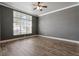 Bedroom with hardwood floors, large window, and neutral wall colors at 12411 Scarlett Sage Ct, Winter Garden, FL 34787