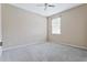 A spare bedroom is carpeted with a neutral paint and a window for natural light at 12411 Scarlett Sage Ct, Winter Garden, FL 34787