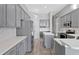Well-equipped kitchen featuring gray cabinets, stainless steel appliances, subway tile backsplash, and an island at 12411 Scarlett Sage Ct, Winter Garden, FL 34787