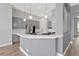 Stylish kitchen with gray cabinets, white countertops, stainless steel appliances, and modern pendant lighting at 12411 Scarlett Sage Ct, Winter Garden, FL 34787