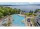 Aerial view of a community pool and surrounding landscape by the lake at 13415 Blue Heron Beach Dr # 710, Orlando, FL 32821