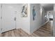 Hallway with a white front door, modern artwork, and wood-look flooring at 13415 Blue Heron Beach Dr # 710, Orlando, FL 32821