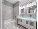 Elegant bathroom with dual glass vessel sinks, mosaic tile, and a soaking tub at 14526 Chicora Crossing Blvd, Orlando, FL 32828