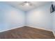 A blue painted bedroom with a ceiling fan and hardwood flooring offers a cozy space at 14526 Chicora Crossing Blvd, Orlando, FL 32828