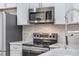 Close-up of a modern kitchen with stainless steel appliances and white cabinets at 14526 Chicora Crossing Blvd, Orlando, FL 32828