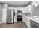 Spacious kitchen featuring stainless steel appliances, white cabinets, and wood-look floors at 14526 Chicora Crossing Blvd, Orlando, FL 32828