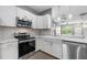 Modern kitchen featuring stainless steel appliances, white cabinets, and a farmhouse sink at 14526 Chicora Crossing Blvd, Orlando, FL 32828