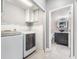 Bright laundry room with modern washer/dryer, built-in cabinets, and access to a stylish bathroom at 14526 Chicora Crossing Blvd, Orlando, FL 32828