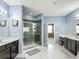 Beautiful bathroom with a walk-in shower, double vanity, and stylish gray tile at 14962 Fells Ln, Orlando, FL 32827