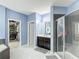 Bathroom featuring a dual sink vanity, walk-in shower, and soaking tub at 14962 Fells Ln, Orlando, FL 32827