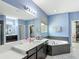 Bathroom featuring a dual sink vanity, soaking tub, and walk-in closet at 14962 Fells Ln, Orlando, FL 32827