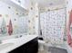 Well-lit bathroom featuring a vanity sink, a toilet, and a shower with a patterned shower curtain at 14962 Fells Ln, Orlando, FL 32827