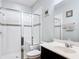 Modern bathroom with a glass-enclosed shower, vanity sink, and white tile, offering a clean and stylish design at 14962 Fells Ln, Orlando, FL 32827