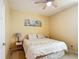 A cozy bedroom features a neutral color scheme, ceiling fan, and a comfortable bed with decorative pillows at 14962 Fells Ln, Orlando, FL 32827