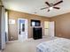 Spacious bedroom featuring a ceiling fan, walk-in closet, and mounted TV at 14962 Fells Ln, Orlando, FL 32827