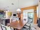 Open-concept kitchen and dining area with wood table, view to adjacent living room, and access to outdoor patio at 14962 Fells Ln, Orlando, FL 32827