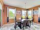 A dining room features a wood table, stylish chairs, and an abundance of natural light from multiple windows at 14962 Fells Ln, Orlando, FL 32827