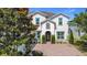 Charming two-story home with a well-manicured lawn, beautiful landscaping, and a welcoming brick driveway at 14962 Fells Ln, Orlando, FL 32827