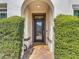 Arched front door with ornate glass, framed by manicured bushes and brick walkway at 14962 Fells Ln, Orlando, FL 32827