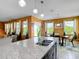 The kitchen island features granite countertops, a double sink, and seating for four, connecting to the dining area at 14962 Fells Ln, Orlando, FL 32827