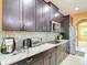 Elegant kitchen features dark wood cabinets, stainless appliances and speckled granite countertops at 14962 Fells Ln, Orlando, FL 32827