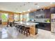 The kitchen has dark cabinets, stainless appliances, a center island with seating, and views of the dining area at 14962 Fells Ln, Orlando, FL 32827