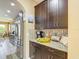 A kitchen boasts dark wood cabinetry, stainless steel appliances, and mosaic backsplash at 14962 Fells Ln, Orlando, FL 32827